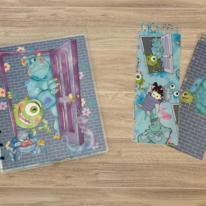 May include: A blue and green planner with a Monsters Inc. theme. The cover features a door with Sully and Mike peeking out. The planner has a spiral binding and a clear plastic cover. The other two images show matching bookmarks with the words "MONTH" and "BUDGET" printed on them.