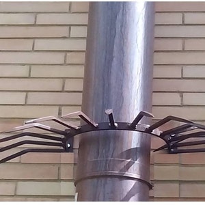 May include: A metal chimney cap with multiple pointed prongs to prevent birds from nesting. The cap is attached to a round, gray chimney pipe.