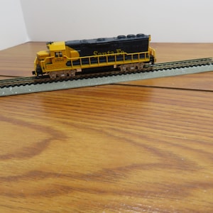 May include: A set of three ceramic mugs with a speckled, matte finish. The mugs are in shades of cream, light gray, and dark gray. Each mug has a simple, minimalist design, perfect for coffee or tea.