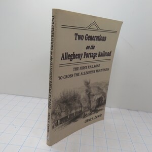 May include: A tan book titled "Two Generations on the Allegheny Portage Railroad" with a black and white illustration of a train on the cover. The subtitle reads "The First Railroad to Cross the Allegheny Mountains".