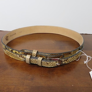May include: A 30-inch leather belt with a python skin pattern in shades of tan, brown, and black. The belt has a silver-tone buckle and a matching belt loop. The interior of the belt is a light tan color.