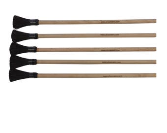 Puede incluir: Cinco cepillos de cerdas negras con mangos de madera. Cada mango tiene el texto "www.al-nawras.com" impreso en él.