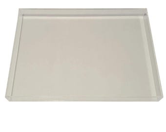 Puede incluir: Una bandeja rectangular de acrílico transparente con una base plana y cuatro lados verticales bajos. La bandeja es transparente y presenta una superficie lisa y pulida en toda su construcción, ofreciendo un diseño limpio y sencillo para objetos.