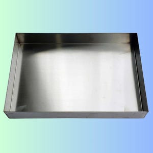 Op de afbeelding: Een rechthoekige roestvrijstalen bak met een geborstelde metalen afwerking. De bak heeft een ondiepe diepte en rechte zijkanten, geschikt voor diverse toepassingen. Het reflecterende oppervlak vangt het licht op.