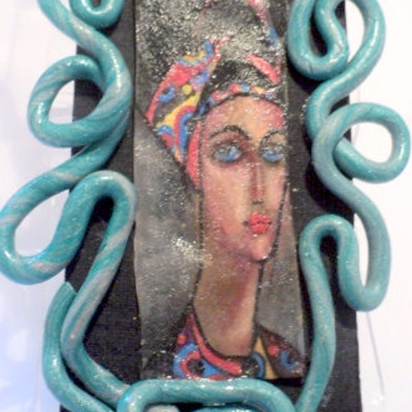 Pendentif en plastique dingue dessin de visage féminin aux pastels encadrement en pâte fimo bleue pendentif fait-mains