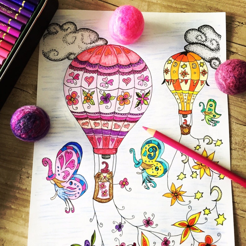 K&ouml;nnte beinhalten: Eine Malvorlage mit zwei Hei&szlig;luftballons, einem rosa und einem gelben, mit aufwendigen Designs. Die Ballons sind von Schmetterlingen, Blumen und Sternen umgeben. Die Seite liegt auf einer Holzoberfl&auml;che mit rosa Wollkugeln.