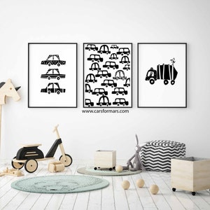 Puede incluir: Tres impresiones enmarcadas en blanco y negro de coches y camiones. Las impresiones est&aacute;n colgadas en una pared blanca en una habitaci&oacute;n infantil. La habitaci&oacute;n tiene un suelo de madera, una alfombra y un scooter de juguete de madera.