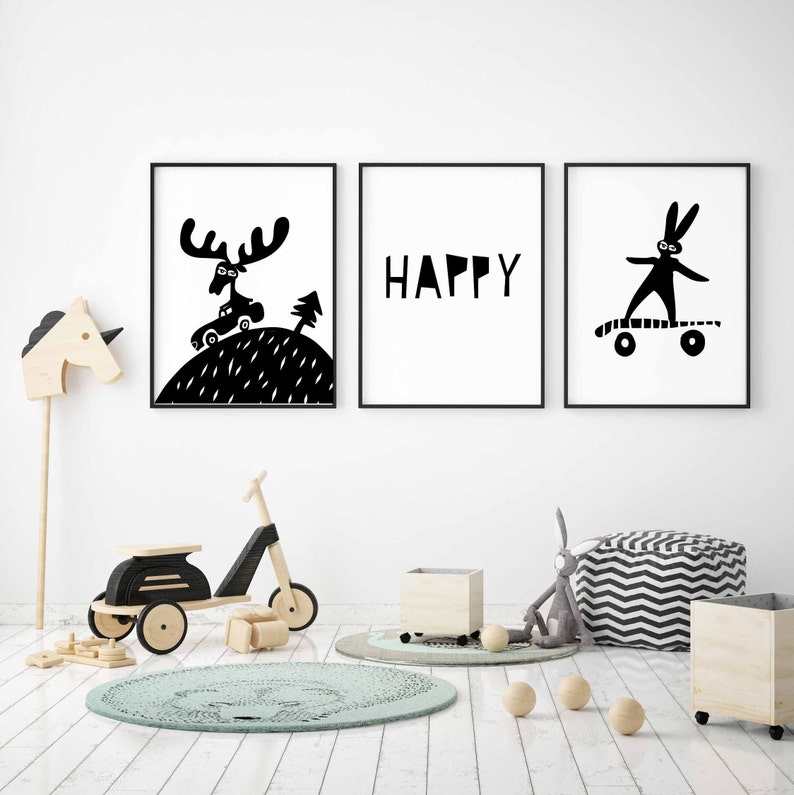 May include: Three black and white framed prints with illustrations. The first print shows a moose with a car on its back, the second print says "HAPPY" and the third print shows a rabbit on a skateboard.