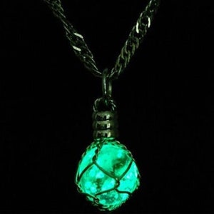 May include: A black chain necklace with a glowing green glass orb pendant encased in a wire cage.