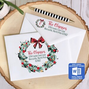 May include: A printable Christmas envelope template featuring a green and gold wreath with red berries and a red bow. The text "The Clauses" is printed in red with the address "1214 Candy Cane Lane, Merryville, North Pole 02482".