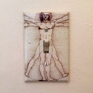 May include: A light switch cover with a black and white image of a person with arms outstretched.