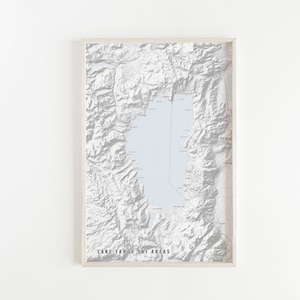 May include: A framed map of Lake Tahoe ski areas, with a light blue background and gray topographical lines. The map shows the location of various ski resorts around the lake.