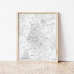 May include: A framed map with a light gray background and black text. The map is titled "Tobacco Roots" and shows a detailed topographical map of a mountainous region. The map is framed in a light wood frame.