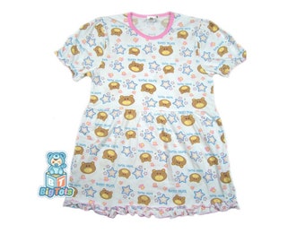 May include: A white short-sleeved dress with a pink trim and a pattern of brown bears and blue stars. The dress has a ruffled hem and says "Baby Bears" on the front.
