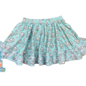 May include: A turquoise skirt with a gray elephant and pink heart print. The skirt has a white ruffle trim.
