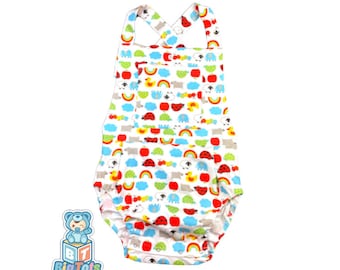 May include: White baby romper with a colorful pattern of animals, rainbows, and clouds. The romper has a criss-cross strap design and a ruffled bottom.