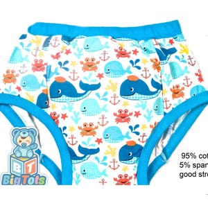 May include: White baby underwear with a blue trim and a pattern of whales, anchors, and crabs. The underwear has a good stretch and is made of 95% cotton and 5% spandex. The Big Tots logo is visible in the lower left corner.