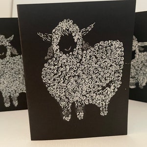 May include: Three black cards with white illustrations of sheep. Each sheep is drawn with a curly, textured wool pattern.