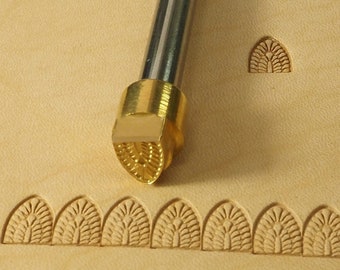 May include: A brass leather stamping tool with a decorative design. The tool is used to create a repeating pattern on leather. The tool is shown with a sample of the pattern it creates.