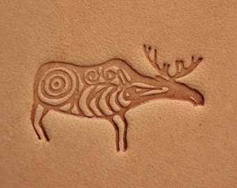 May include: A brown leather background with a stylized moose design embossed in the leather. The moose is facing left and has a detailed design on its body.