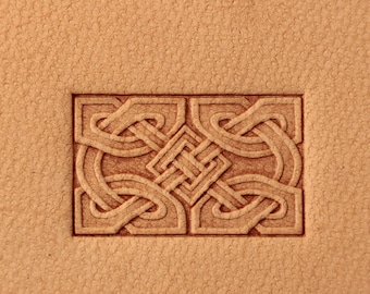 May include: A close-up of a leather stamp featuring a Celtic knot design. The stamp is rectangular and has a raised design.