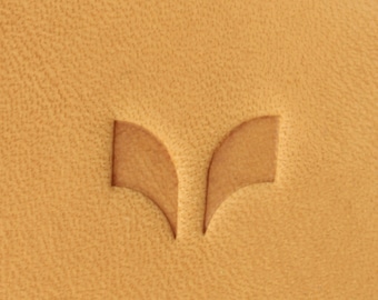 May include: A close-up of a light brown leather surface with a small, embossed, double-winged logo in the center.