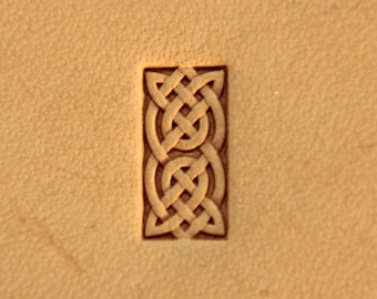May include: A close-up of a leather stamp featuring a Celtic knot design. The stamp is rectangular and has a raised design.