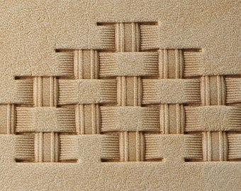 May include: A close-up of a light brown leather surface with a woven pattern embossed into the material. The pattern is a series of squares and rectangles that create a geometric design.