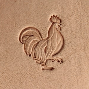 Peut inclure: Une sculpture détaillée d'un coq sur un morceau de cuir brun clair.
