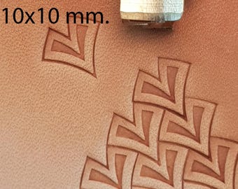 May include: Close-up of a leather stamping tool and stamped leather. The tool is silver and the leather is tan. The stamped design is a repeating geometric pattern. The text "No 100" and "10x10 mm" are visible.