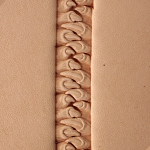 Puede incluir: Un primer plano de una herramienta de artesanía en cuero con un patrón repetitivo de líneas curvas y puntos. La herramienta está diseñada para crear un borde decorativo en artículos de cuero.