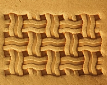 May include: A close-up of a leather stamp with a woven pattern. The stamp is made of brown leather and has a raised design.