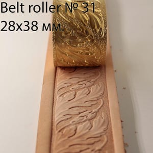 May include: A brass belt roller, labelled "Belt roller № 31", is shown pressing a leaf pattern into a strip of tan leather. The roller measures 2.8x3.8 cm. The embossed leather shows a detailed floral design.