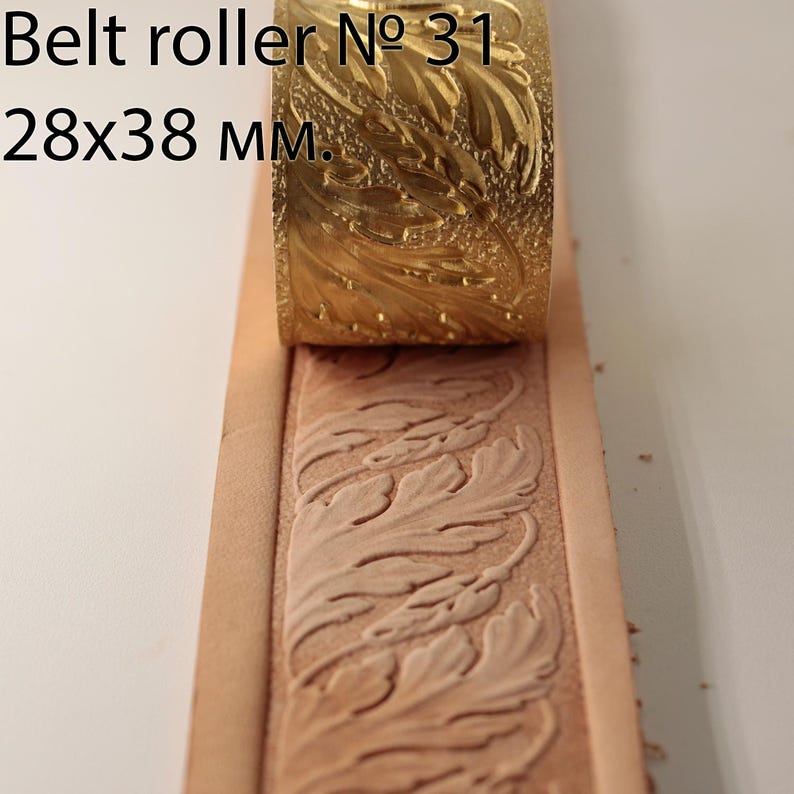 May include: A brass belt roller, labelled "Belt roller № 31", is shown pressing a leaf pattern into a strip of tan leather. The roller measures 2.8x3.8 cm. The embossed leather shows a detailed floral design.