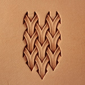 以下が含まれることがあります： 重なり合う尖った形が複雑に組み合わされた、革細工のプロジェクトのクローズアップ。デザインは革にエンボス加工されており、浮き上がった模様が作られています。