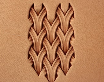 Puede incluir: Primer plano de un proyecto de artesanía en cuero con un diseño detallado e intrincado de formas puntiagudas superpuestas. El diseño está estampado en el cuero, creando un patrón en relieve.