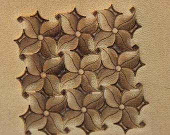 May include: A close-up of a leather craft project with a repeating pattern of carved flowers. The flowers are brown and the background is a light tan.