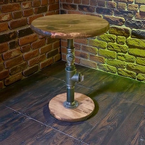 May include: A rustic side table with a round, wooden top and base. The table's support is made of industrial-style metal pipes and fittings. The table is approximately 20 inches in diameter and 24 inches tall.