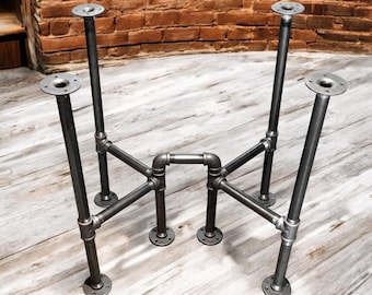Puede incluir: Patas de mesa de estilo industrial hechas de tuberías y accesorios de metal gris oscuro. Las patas tienen un diseño robusto con placas de montaje circulares en la parte superior e inferior, conectadas por una red de tuberías. Las patas están diseñadas para una mesa.