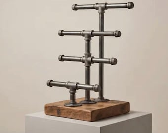 Puede incluir: Un expositor de joyas hecho de tuberías metálicas y una base de madera. El expositor tiene múltiples barras horizontales para exhibir artículos. El texto "Untangle Your Life, Showcase Your Style" está en la parte superior.