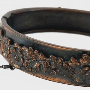Pulsera rígida vintage de cobre con diseño floral estilo Art Nouveau y cadena de seguridad con bisagra.