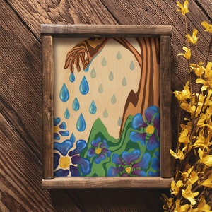 Puede incluir: Una pintura enmarcada de un &aacute;rbol estilizado con una mano que se extiende hacia abajo y gotea gotas de lluvia azules sobre un campo de flores azules con centros amarillos.