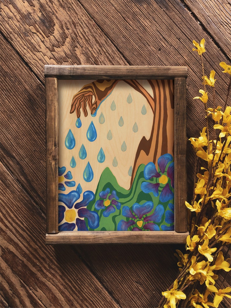 Puede incluir: Una pintura enmarcada de un &aacute;rbol estilizado con una mano que se extiende hacia abajo y gotea gotas de lluvia azules sobre un campo de flores azules con centros amarillos.