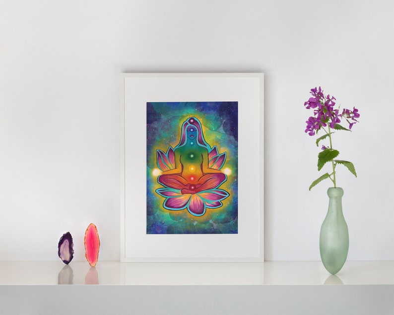 May include: A colorful illustration of a person meditating in a lotus position with seven chakras represented by different colors. The background is a dark blue with stars and a light blue and green watercolor effect.