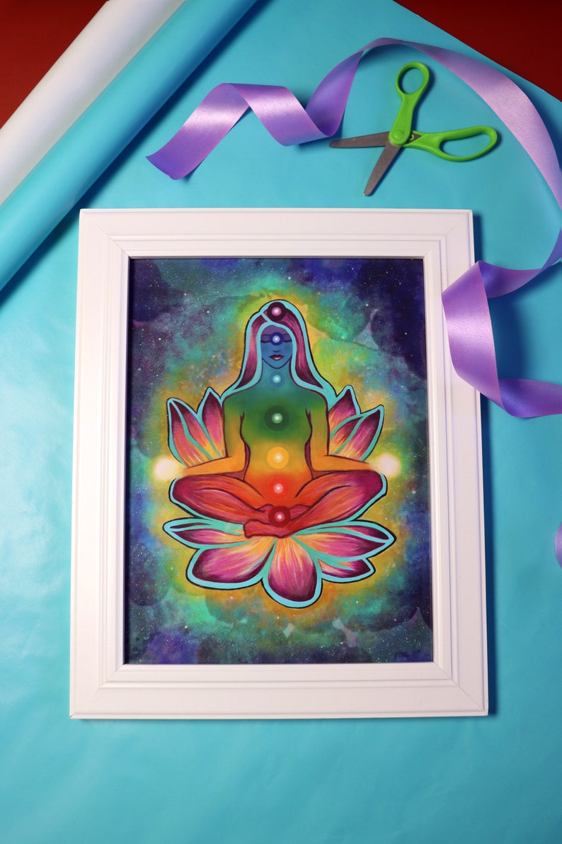May include: A framed painting of a woman meditating in a lotus position with a rainbow aura. The woman is surrounded by a galaxy background with stars and nebulae.