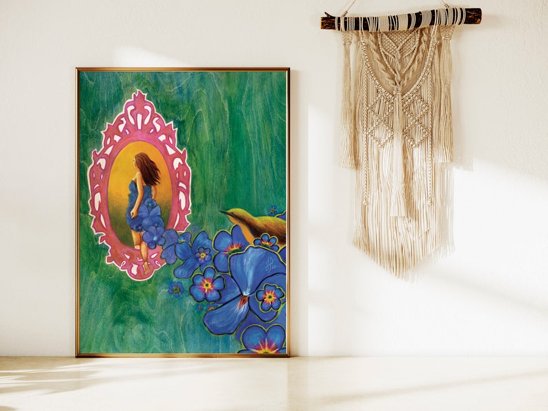 May include: A painting of a woman in a blue dress standing in a pink ornate frame, surrounded by blue flowers and a small bird. The background is a green and blue abstract design.