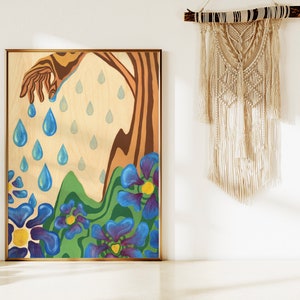 Puede incluir: Una pintura sobre un panel de madera que representa una mano que se extiende desde un &aacute;rbol, con gotas de lluvia azules que caen de la mano y el &aacute;rbol. El fondo es de color madera claro con flores azules y verdes en la parte inferior.