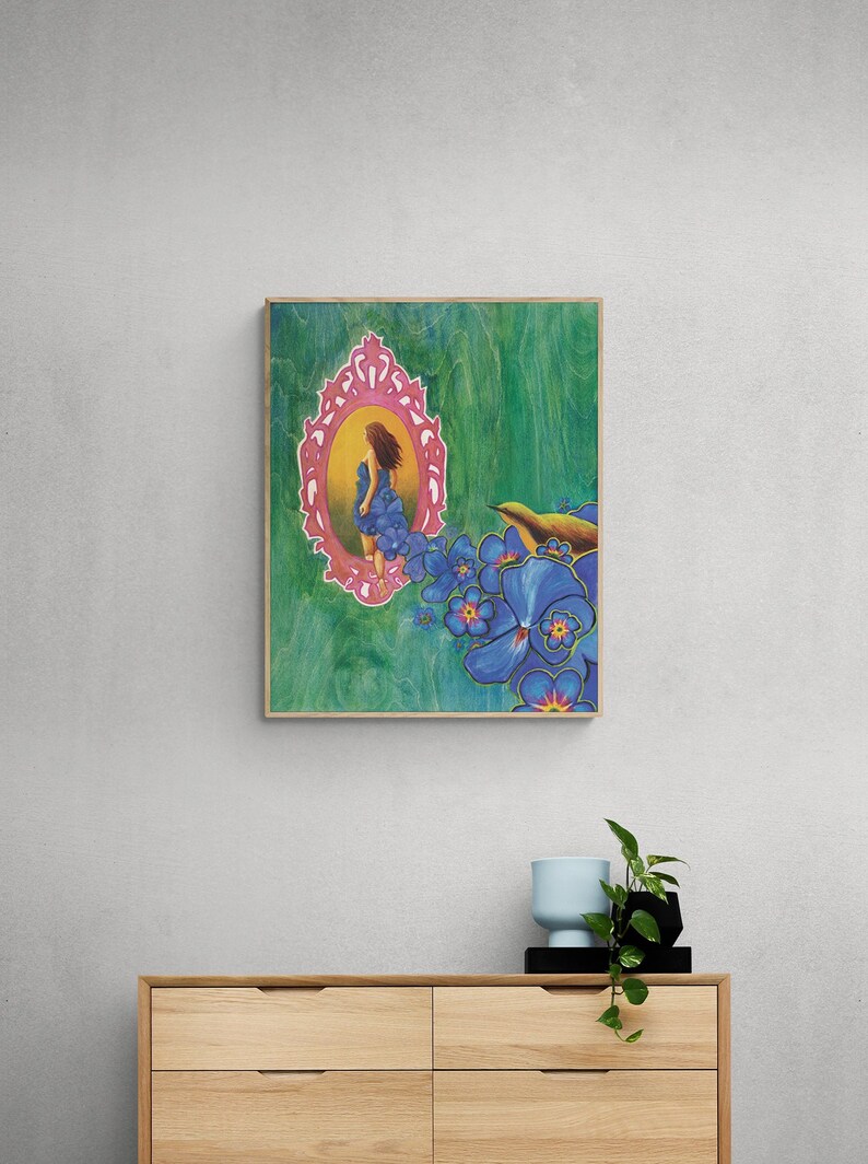 May include: A painting of a woman in a blue dress standing in a pink ornate mirror. The mirror is surrounded by blue flowers and a small bird. The background is a green and blue abstract design.
