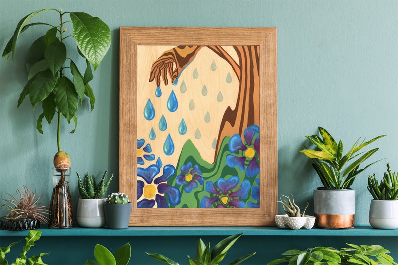 Puede incluir: Una pintura enmarcada con una mano estilizada que vierte gotas de lluvia azules sobre un paisaje de colinas verdes y flores azules.