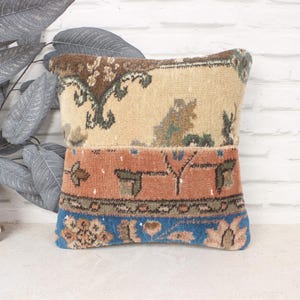 Peut inclure: Un coussin décoratif avec un motif patchwork en bleu, marron, beige et rouge. Le coussin présente un motif floral traditionnel.